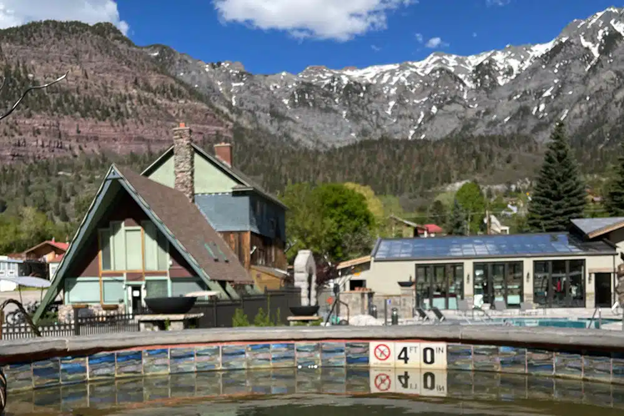 Mountain resort pool with snowy peaks in the background.